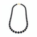 Black beaded necklace and earrings on a white background