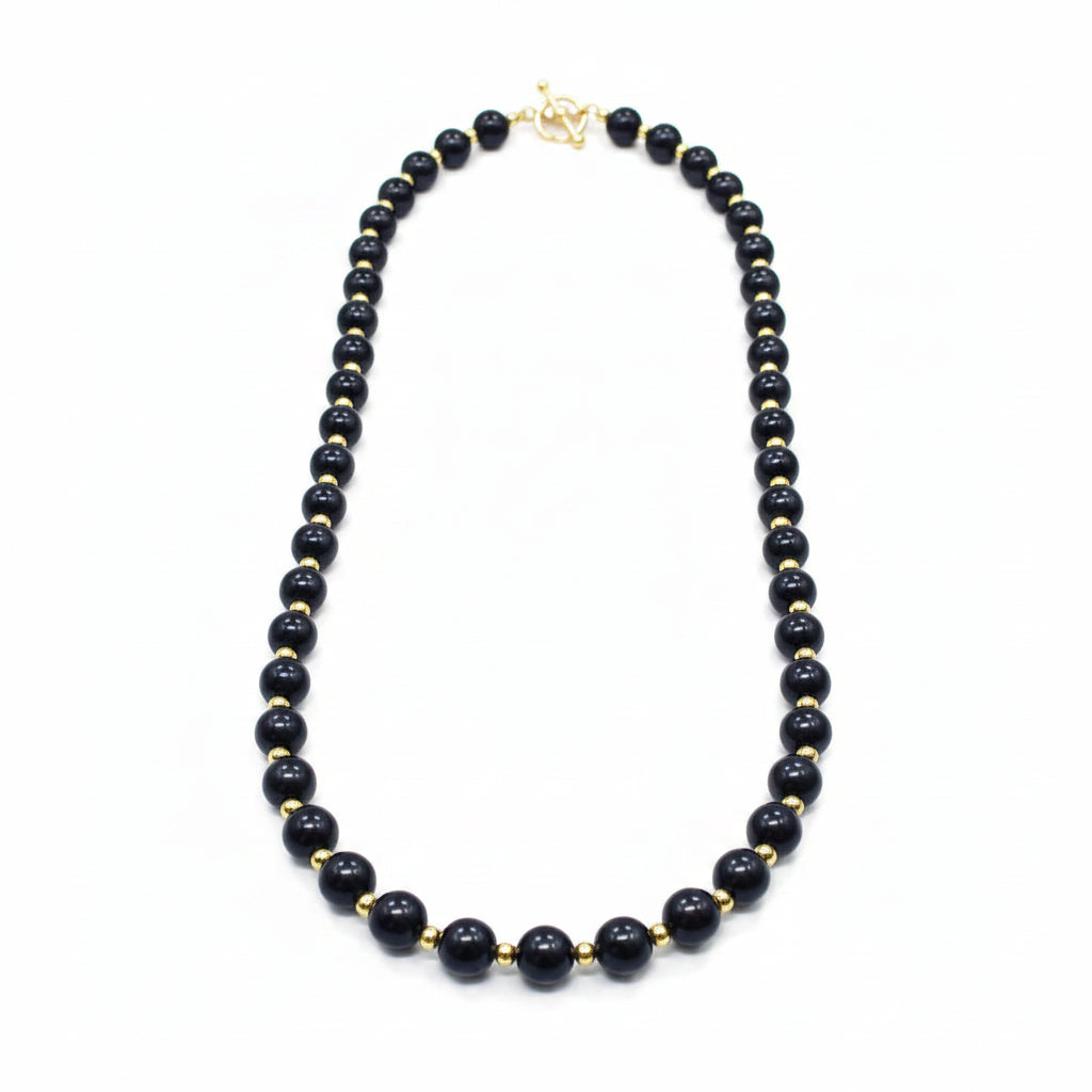 Black beaded necklace and earrings on a white background
