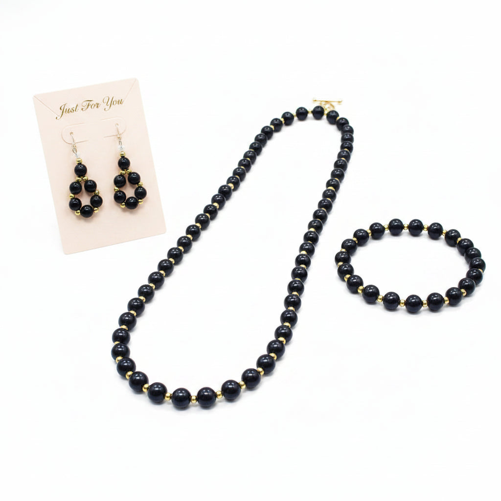 Black beaded necklace and earrings on a white background