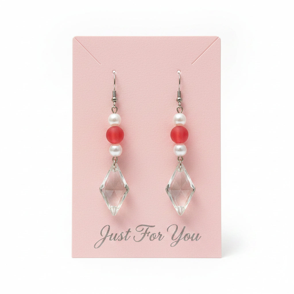 Earrings with red and white pearl beads and clear on a neutral background