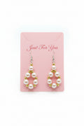 Pearl earrings with gold accents on a dark surface
