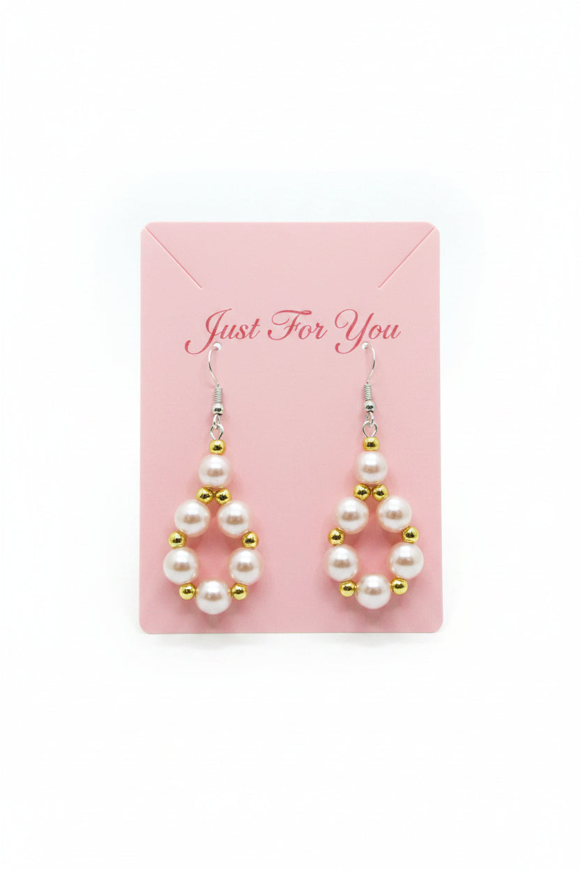 Pearl earrings with gold accents on a dark surface