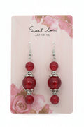 Red beaded earrings on a decorative card with 'sweet love' text.