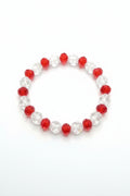Bracelet with red and clear beads on a wooden surface