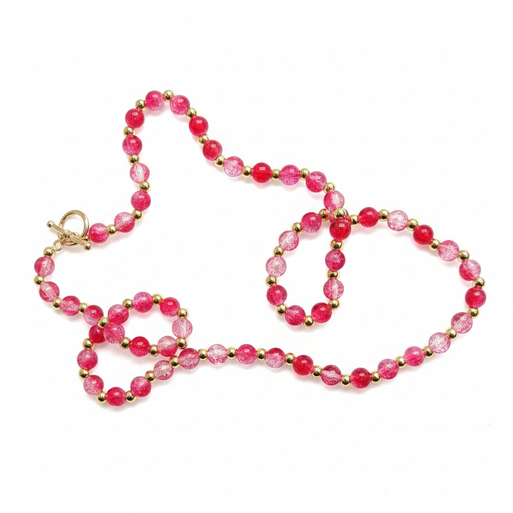 Beaded bracelet with pink beads on a textured gray surface