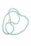Turquoise pearl necklace on a textured stone surface