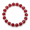 Red beaded bracelet with gold accents on a purple fabric background