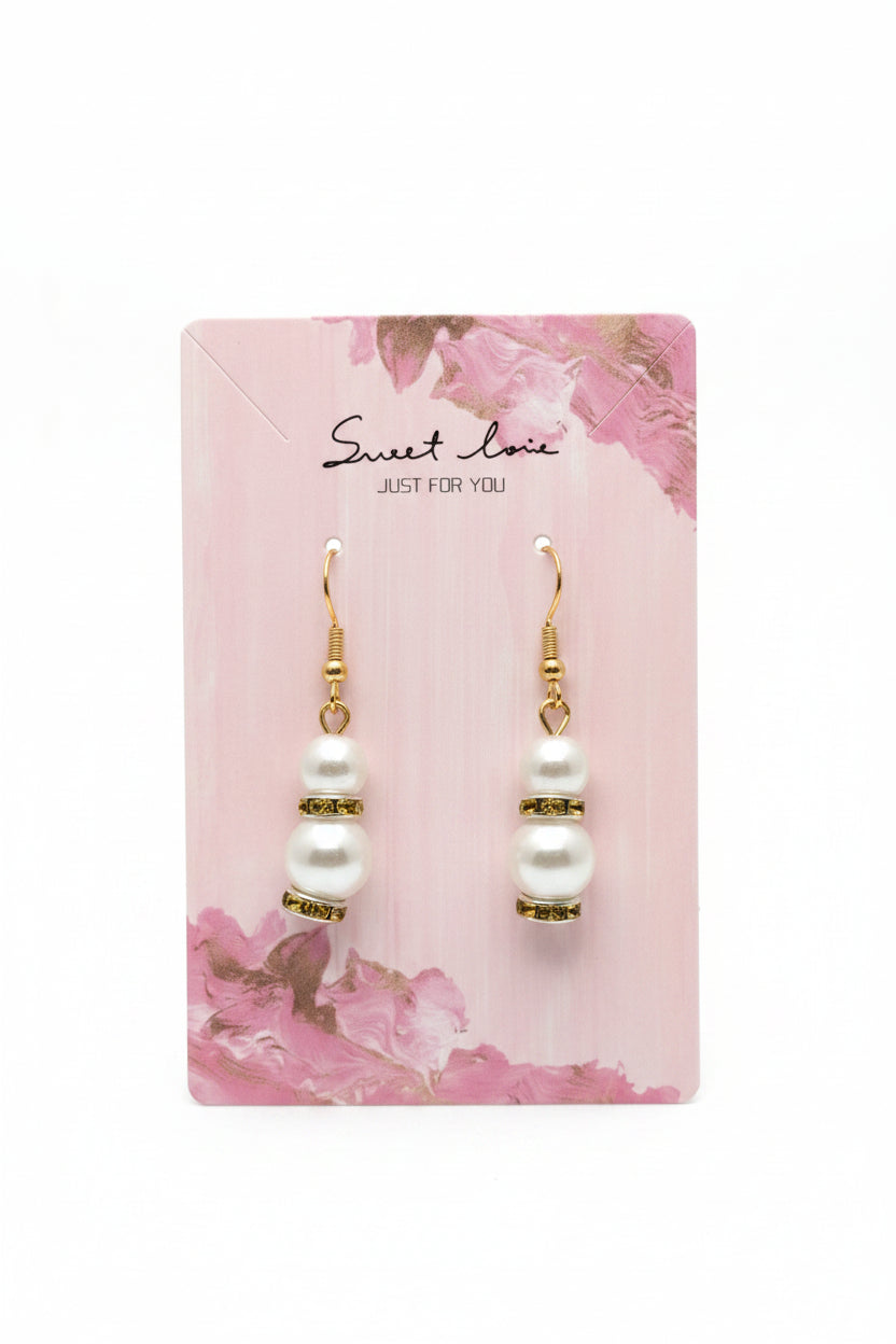 Pearl earrings on a 'Sweet Love' branded card with a purple and floral background