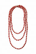 Red crystal beaded necklace with gold spacers on a textured white background